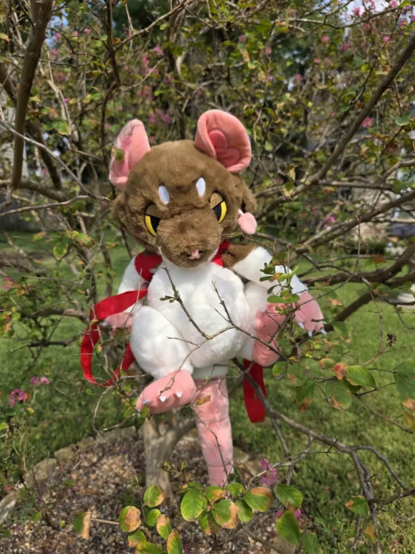 A plush backpack that looks like a brown and white rat