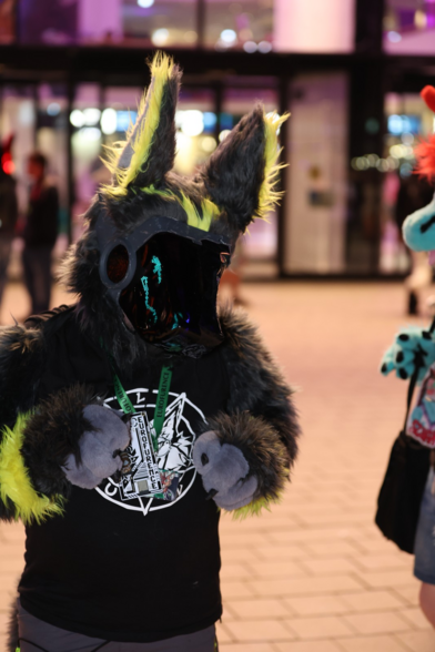 A grey and yellow protogen wearing a xenia linux fox summoning circle tshirt