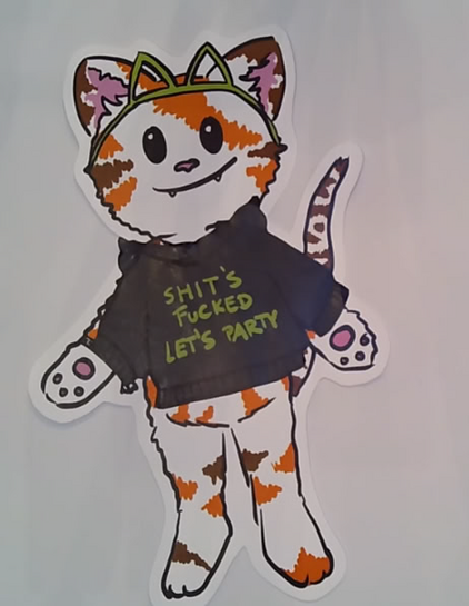 A anthro tabby cat from the opening ceremony talk wearing 3d printed cat ears and a hoodie with "shit's fucked, let's party"
