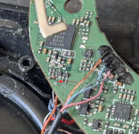 closeup of a PCB with an arrow pointing to a lose capacitor