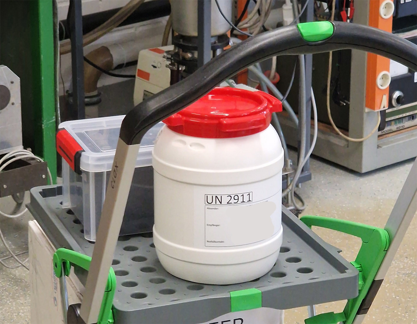 Photo of a small plastic barrel labeled UN 2911 to denote that it contains a radiation source and is an exempt package.