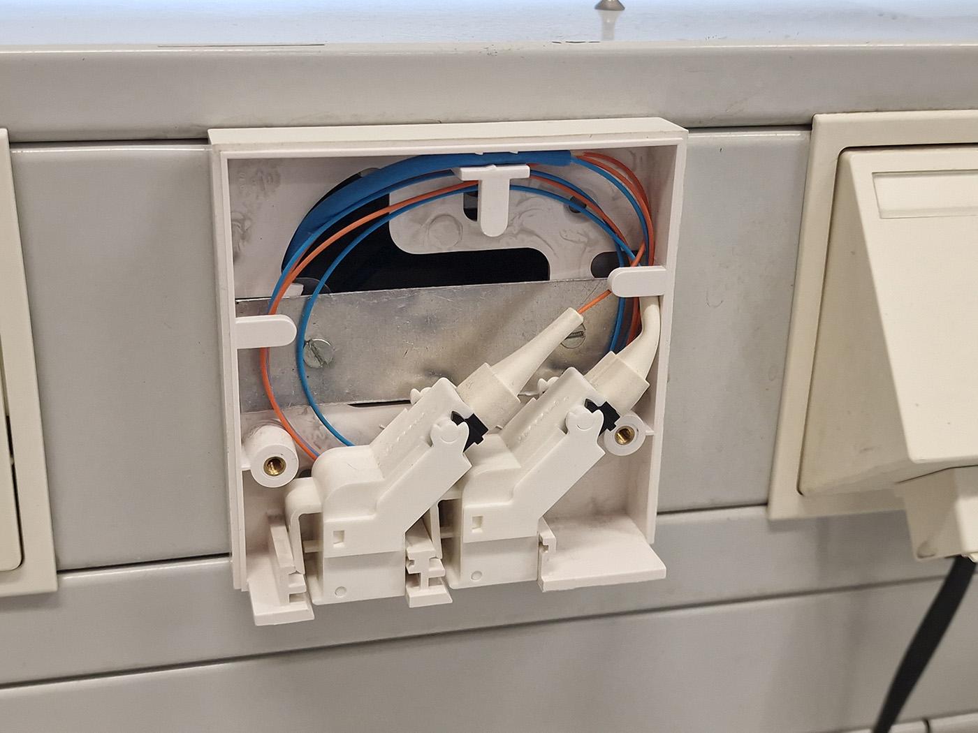 Photo of the same box, with someone pedantic having inserted the fiber ports, taking care to roll the individual fibers up neatly and without sharp bends.