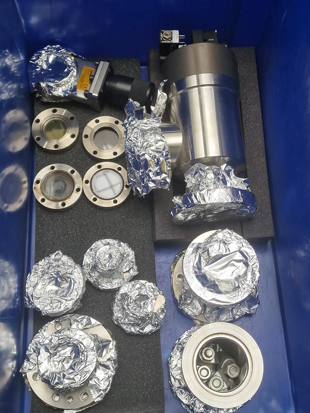Photo of another box of CF flange parts, including a large angle valve.