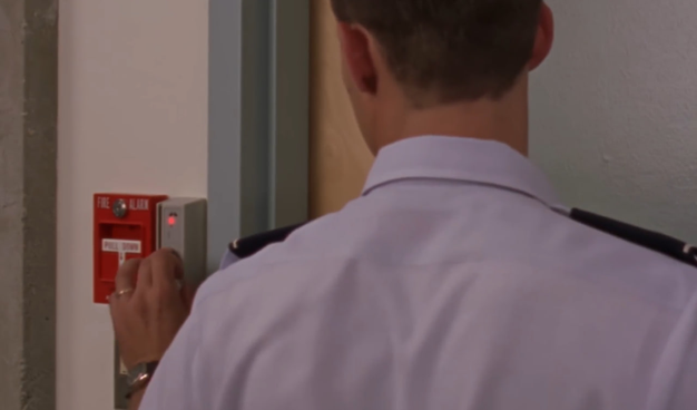 screenshot of Stargate SG1, showing a guard from behind who touching a magnet card reader on the wall