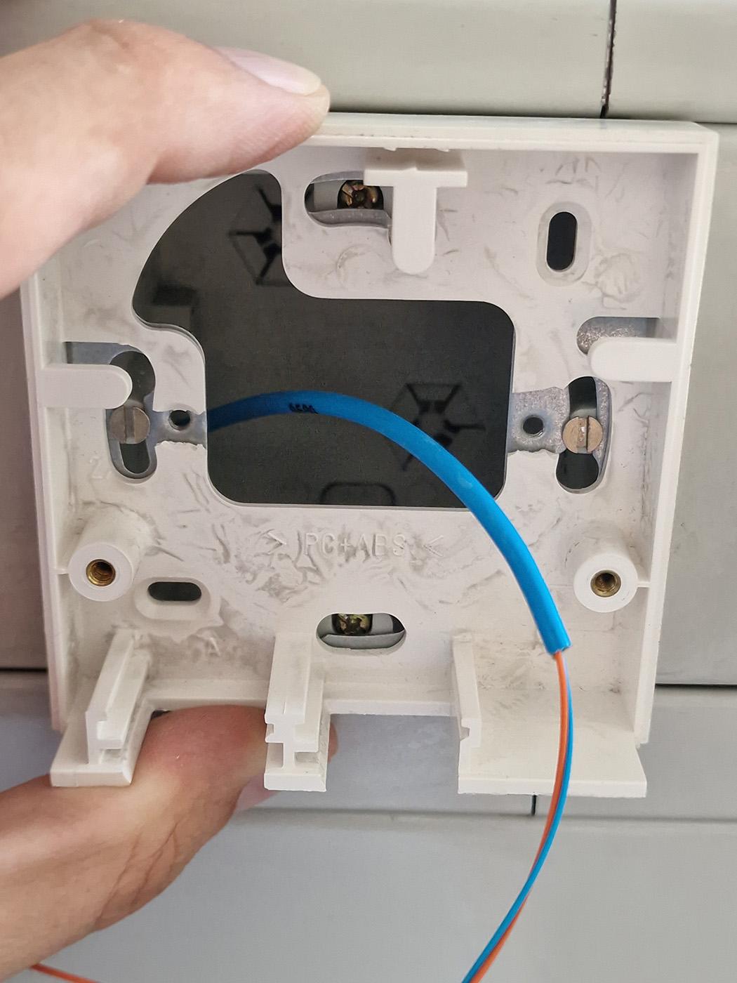 Photo of the back frame of the empty box, showing where the screw holes used to be, but which have broken off, probably due to someone overtightening them. And also because there's just so little material there, I think these things are just destined to break as soon as the softeners move out.